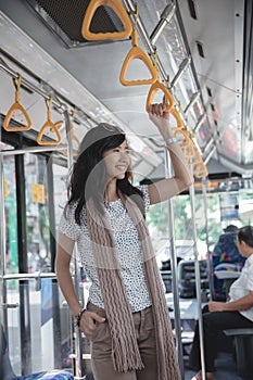 Beautiful young woman standing in bus
