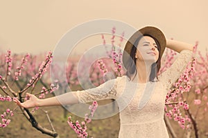 Beautiful young woman standing in front of wonderful blooming tr