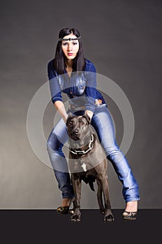 Beautiful young woman standing next to a pitbulls photo