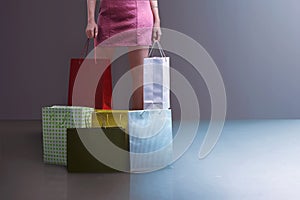 Beautiful young woman standing with shopping bags and boxes