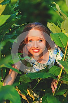 Beautiful young woman standing with a smile. Portrait of a beautiful girl in white dress among trees in the forest. Girl.