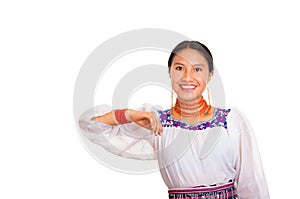 Beautiful young woman standing wearing traditional andean blouse and red necklace, interacting holding out arms smiling