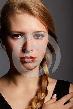 Beautiful young woman with stern look and plait hairstyle