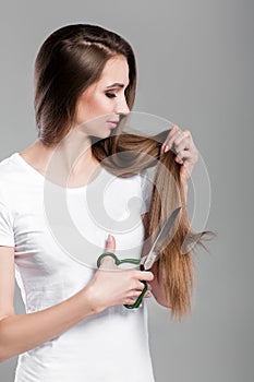 Woman with long hair holds scissors