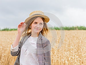 Beautiful young woman with straw boater hat in wheat field, outdoor