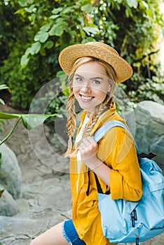 beautiful young woman in straw hat walking down stairs in park and looking photo