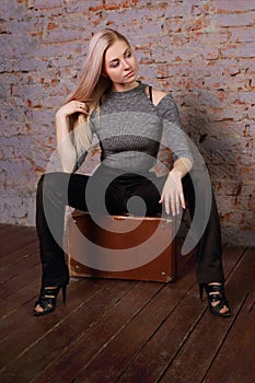 Beautiful young woman posing near brick wall