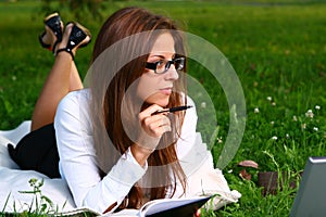 Beautiful young woman studing in park