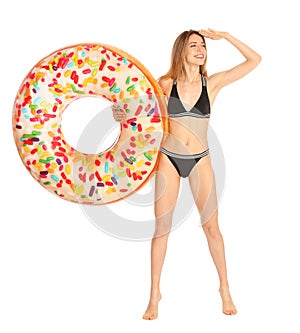 Beautiful young woman in stylish bikini with doughnut inflatable ring