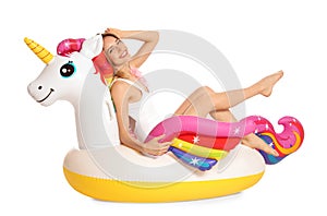 Beautiful young woman in stylish bikini with  unicorn inflatable ring on white