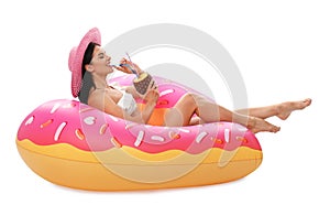 Beautiful young woman in stylish  with cocktail and inflatable ring on white background