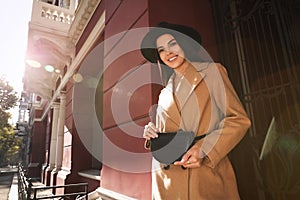 Beautiful young woman with stylish waist bag on city street, space for text