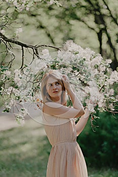 Beautiful young woman in summer garden near blossoming venetian sumi