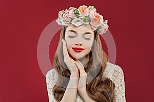 Beautiful young woman with summer pink flowers, long permed curly hair and fashion makeup