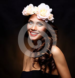 Beautiful Young Woman with Summer Pink Flowers. Long Permed Curly Hair and Fashion Makeup. Beauty Girl with Flowers