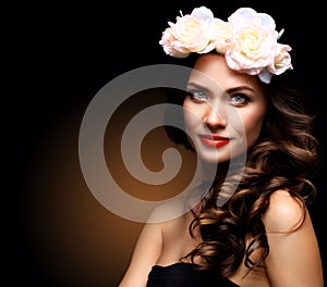 Beautiful Young Woman with Summer Pink Flowers. Long Permed Curly Hair and Fashion Makeup. Beauty Girl with Flowers