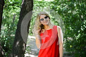 Beautiful young woman in sunglases near the summer park