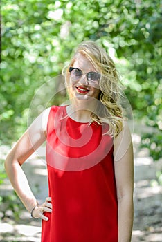 Beautiful young woman in sunglases near the summer park