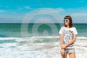 Beautiful young woman in sunglasses posing on the beach of a tropical island of Bali, Indonesia.