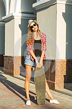 Beautiful young woman in sunglasses with skate, street fashion lifestyle.