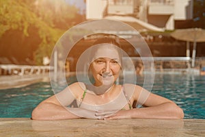 Beautiful young woman swimming in outdoor pool