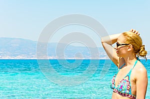 Beautiful young woman in swimsuit, relaxing on a tropical sunny beach