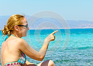 Beautiful young woman in swimsuit, relaxing on a tropical sunny beach