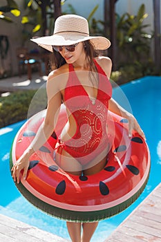 beautiful young woman in swimsuit with watermelon inflatable ring