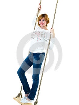 Beautiful young woman on a swing against white studio backgroun