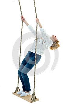 Beautiful young woman on a swing against white studio backgroun
