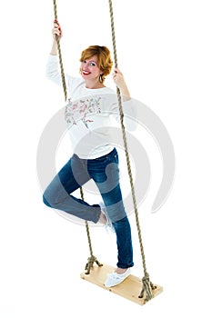 Beautiful young woman on a swing against white studio backgroun