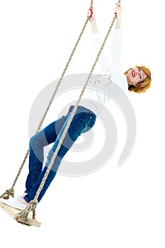 Beautiful young woman on a swing against white studio backgroun