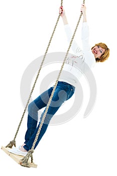 Beautiful young woman on a swing against white studio backgroun