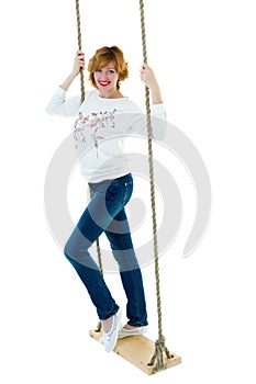 Beautiful young woman on a swing against white studio backgroun