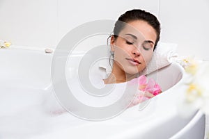 Beautiful young woman takes bubble bath