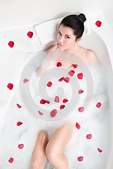 Beautiful young woman takes bubble bath