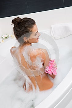 Beautiful young woman taking a bubble bath