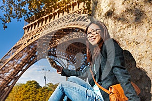 Beautiful young woman taking photo of Eiffel Tower