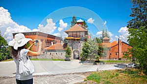 Beautiful young woman taking picture of Monastery Zica, Serbia. photo
