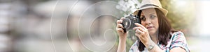 Beautiful young woman taking pictures in a park