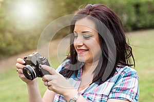 Beautiful young woman taking pictures in a park, light effect
