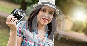 Beautiful young woman taking pictures in a park, light effect