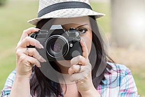 Beautiful young woman taking pictures in a park, light effect