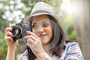 Beautiful young woman taking pictures in a park, light effect