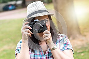 Beautiful young woman taking pictures in a park, light effect