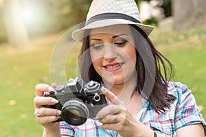 Beautiful young woman taking pictures in a park, light effect