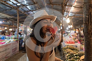 Beautiful Young Woman Tasting Watermelon On Traditional Street Market In Asia Girl Tourist Buying Fresh Fruits On