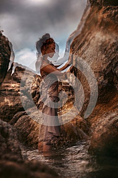 Beautiful young woman touching the rock with eyes closed. double exposure concept