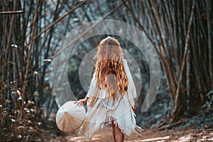 Beautiful young woman tourist in hat at bamboo forest