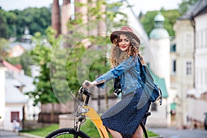 Beautiful young woman tourist traveller with electric scooter in small town.